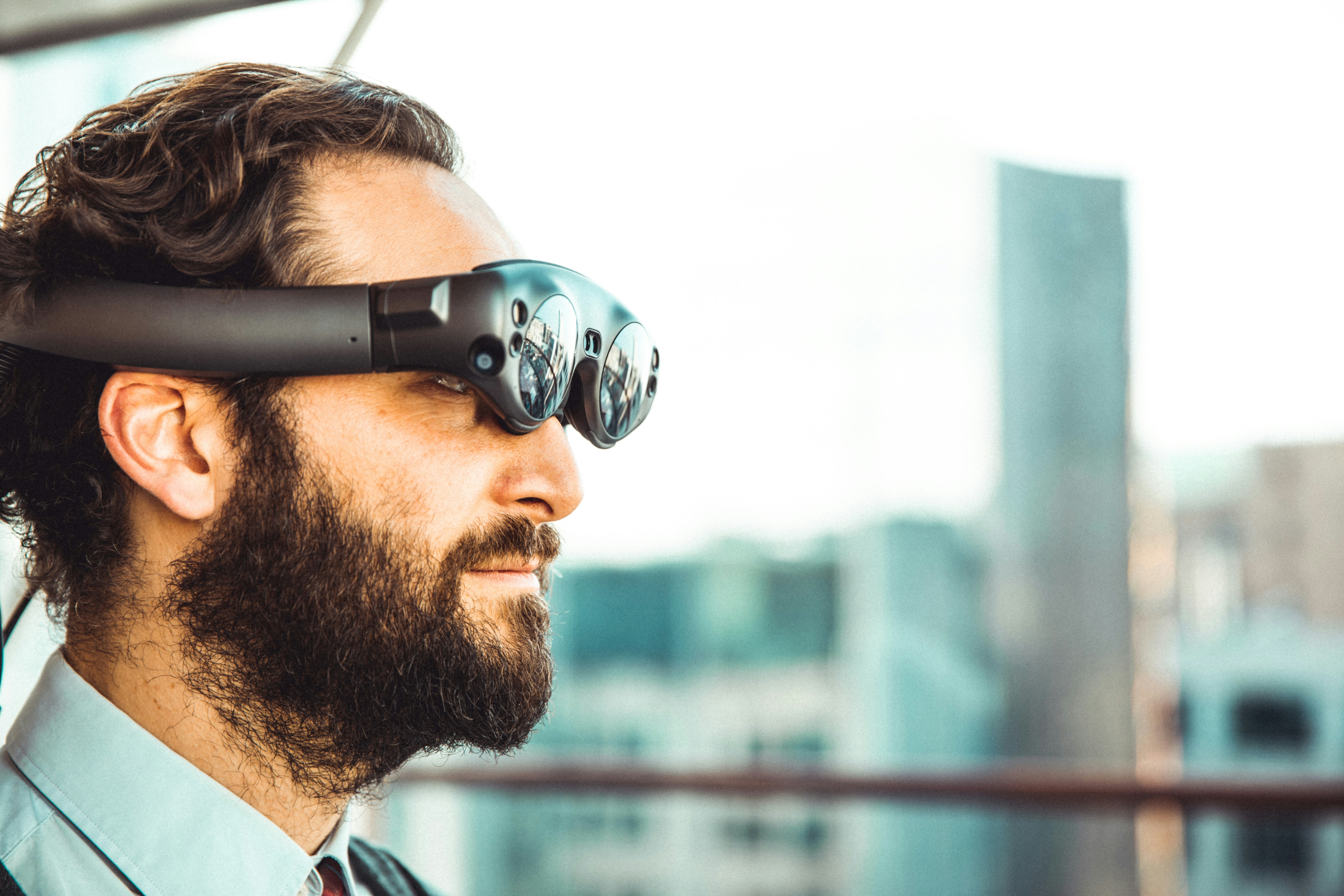 Man wearing AR mixed reality headset with urban cityscape in background