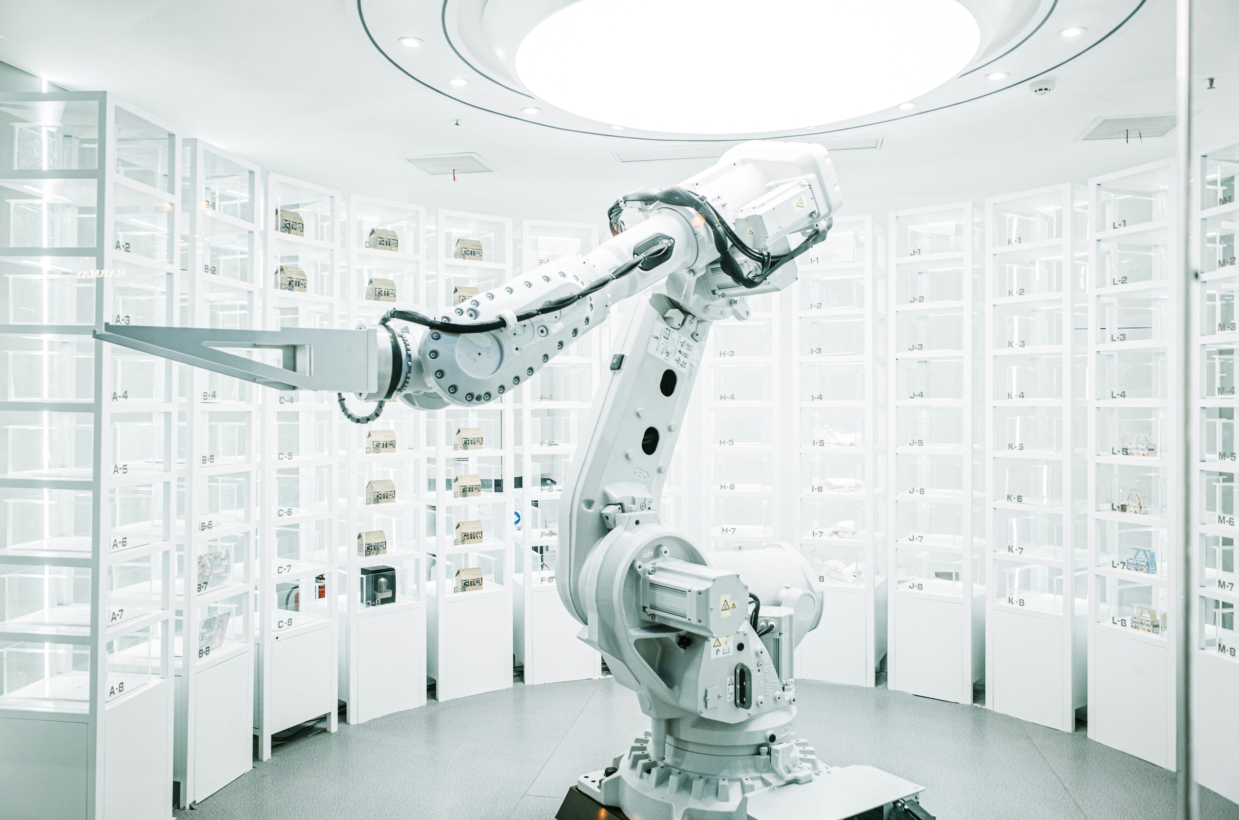 white robot arm picking items from industrial shelves